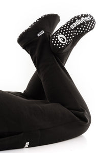 Man wearing lounges loungewear in black with feet up